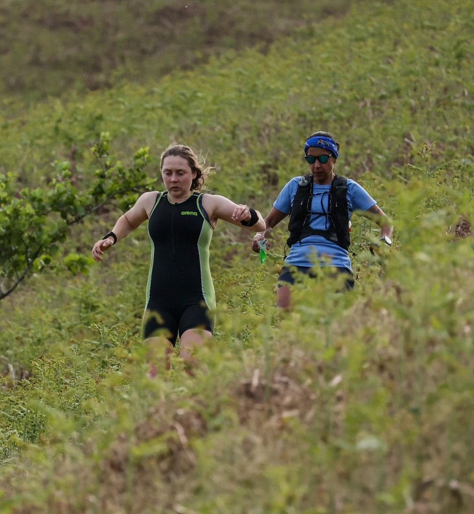 Lauren and Renee running downhill in the foreground, surrounded by bracken