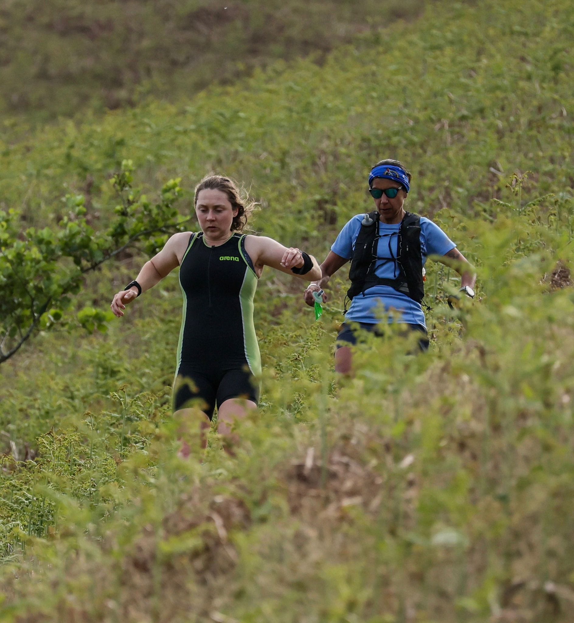 Lauren and Renee running downhill in the foreground, surrounded by bracken